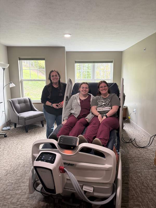 Three caregivers with bed at Trillium House.